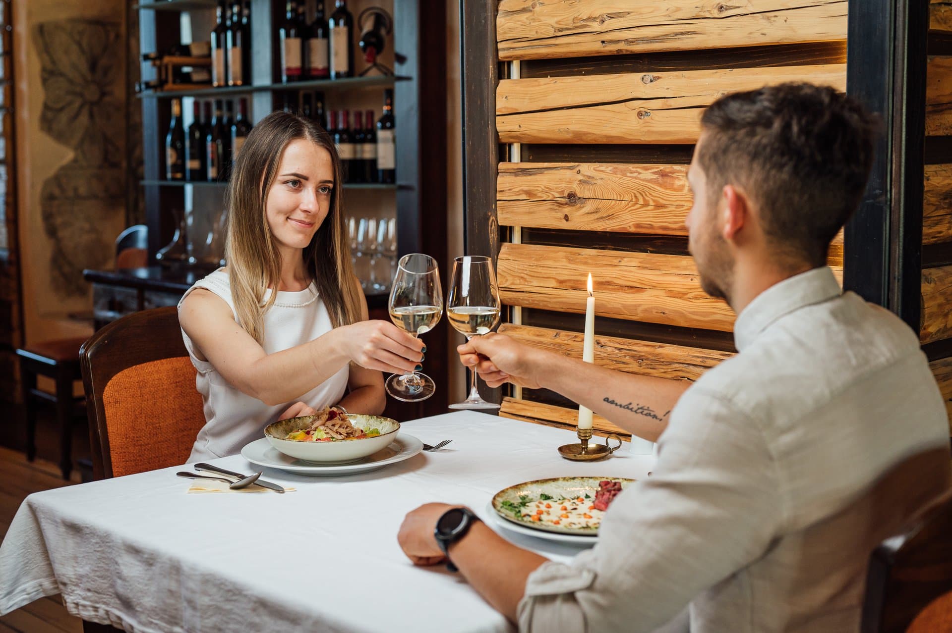 Couple toasting with white wine at a candlelit dinner